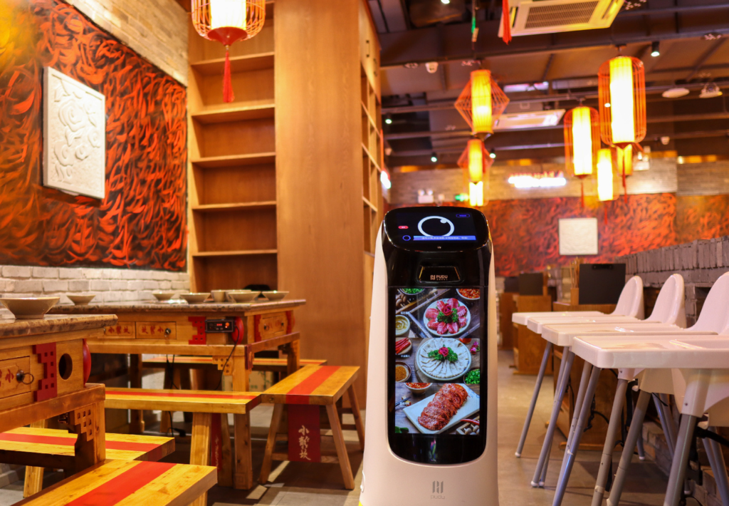 Ketty Bot en un restaurante con su pantalla publicitaria